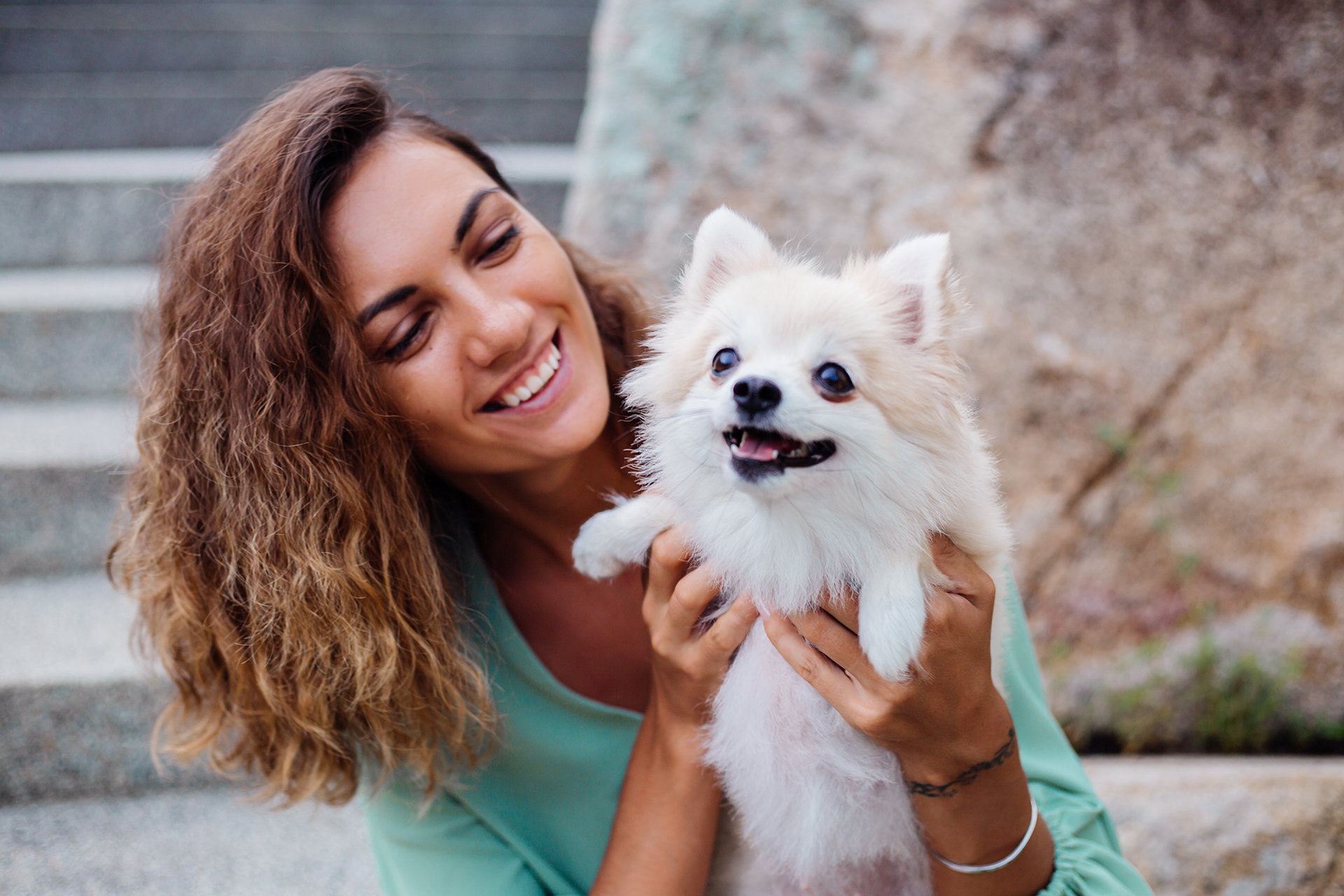 Mulher feliz segurando um cachorro da raça Spitz Alemão limpo e tosado